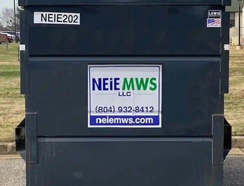 Alt text: A dark dumpster with a blue and green logo reading "NEIE MWS LLC," along with contact information and a website displayed on it.