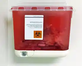 A red biohazard sharps container mounted on a wall.